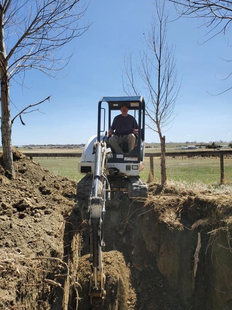 Mini excavator digging trench for sewer line